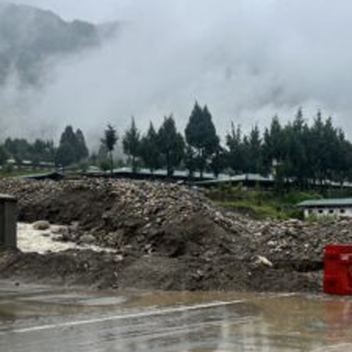 Mud and stones blocking the road after flood in Dechencholing
