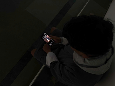 A college student using a smartphone, illustrating screen time among students and its potential impact on sleeping habits.