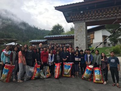 Students cleaning the campus and collecting litter to promote cleanliness and proper waste management.