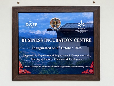Framed plaque on a wall reading "Business Incubation Centre, Inaugurated on 5th October, 2026," with DoEE and Royal Thimphu College logos beside a wooden door.
